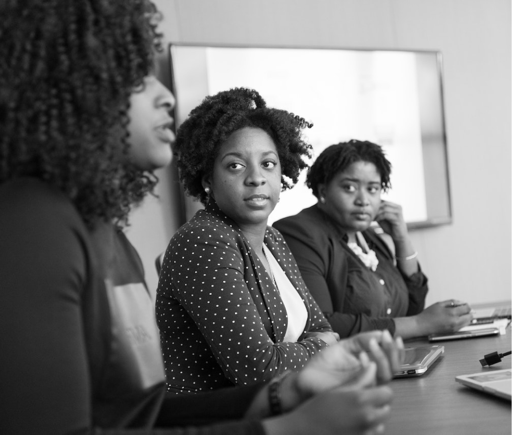 Three black business executives seated over a conference table